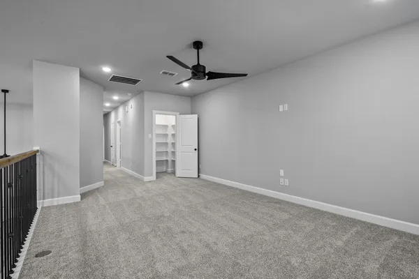 an empty room with fan and entrance