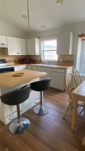 a kitchen with granite countertop a table chairs sink and wooden floor