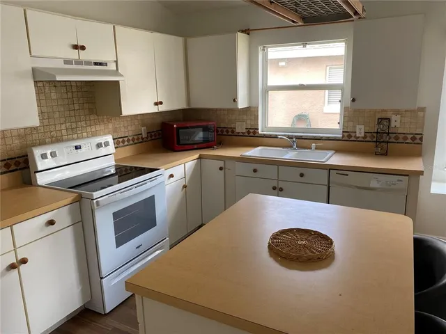 a kitchen with a sink a stove and cabinets