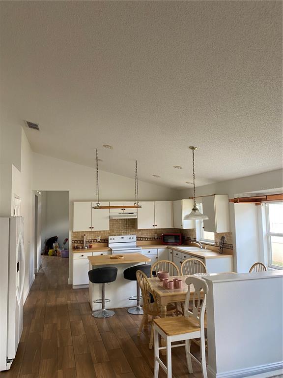 635 Rochester Loop Davenport, FL 33897 - Photo 21 of 22 a living room with stainless steel appliances kitchen island granite countertop a table chairs and a view of living room