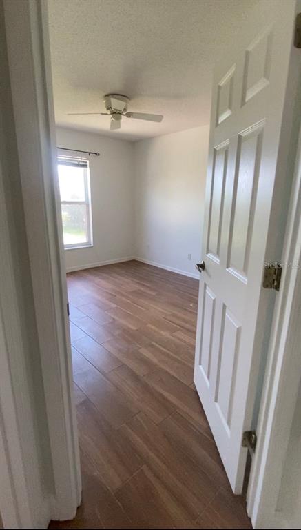 635 Rochester Loop Davenport, FL 33897 - Photo 9 of 22 a view of an empty room with wooden floor and a window