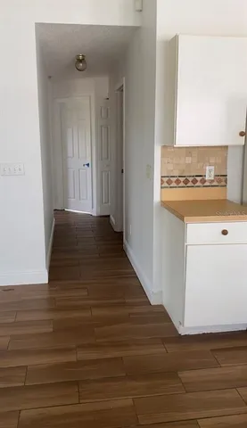 a view of an empty room with wooden floor