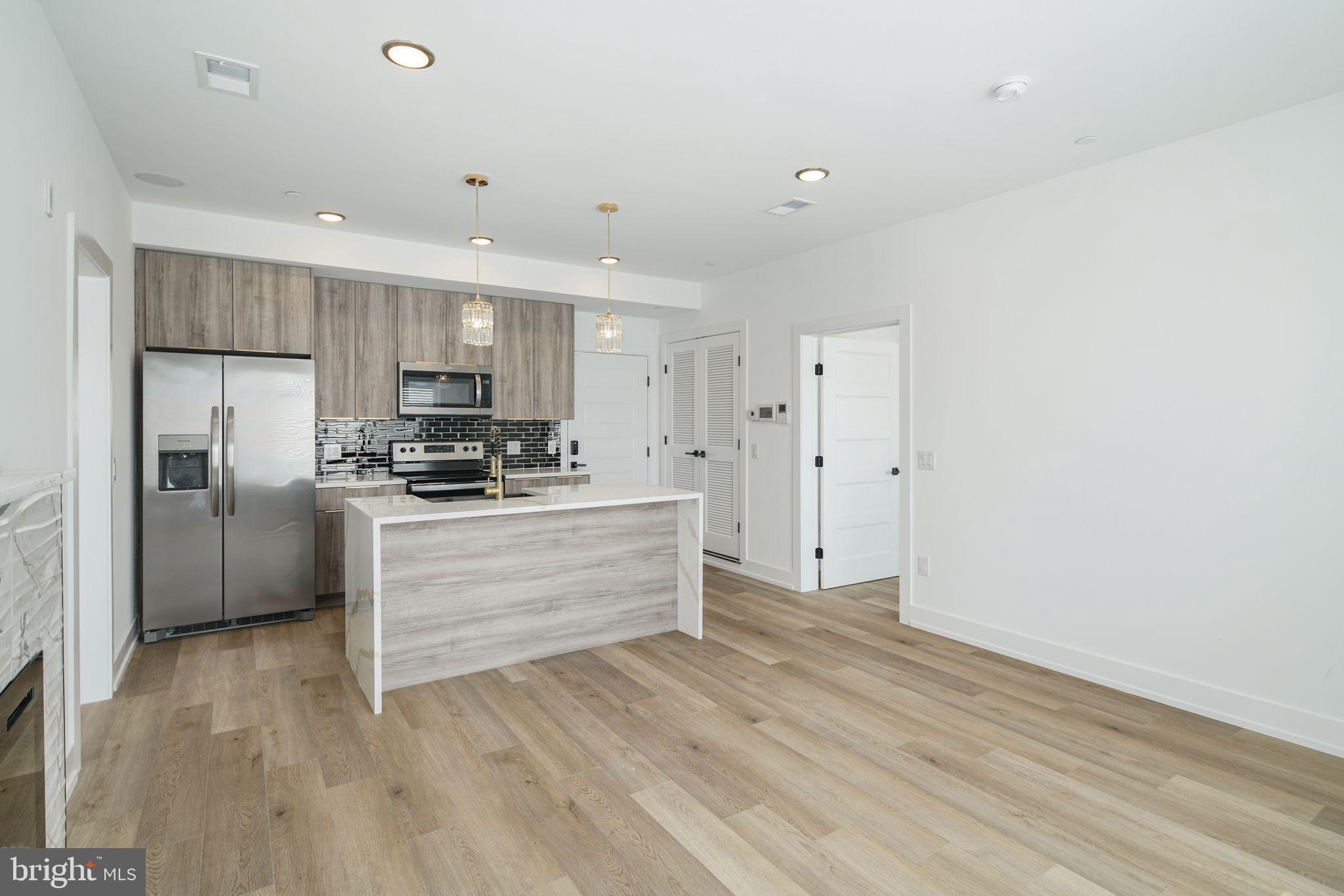 a kitchen with granite countertop a refrigerator and a stove top oven
