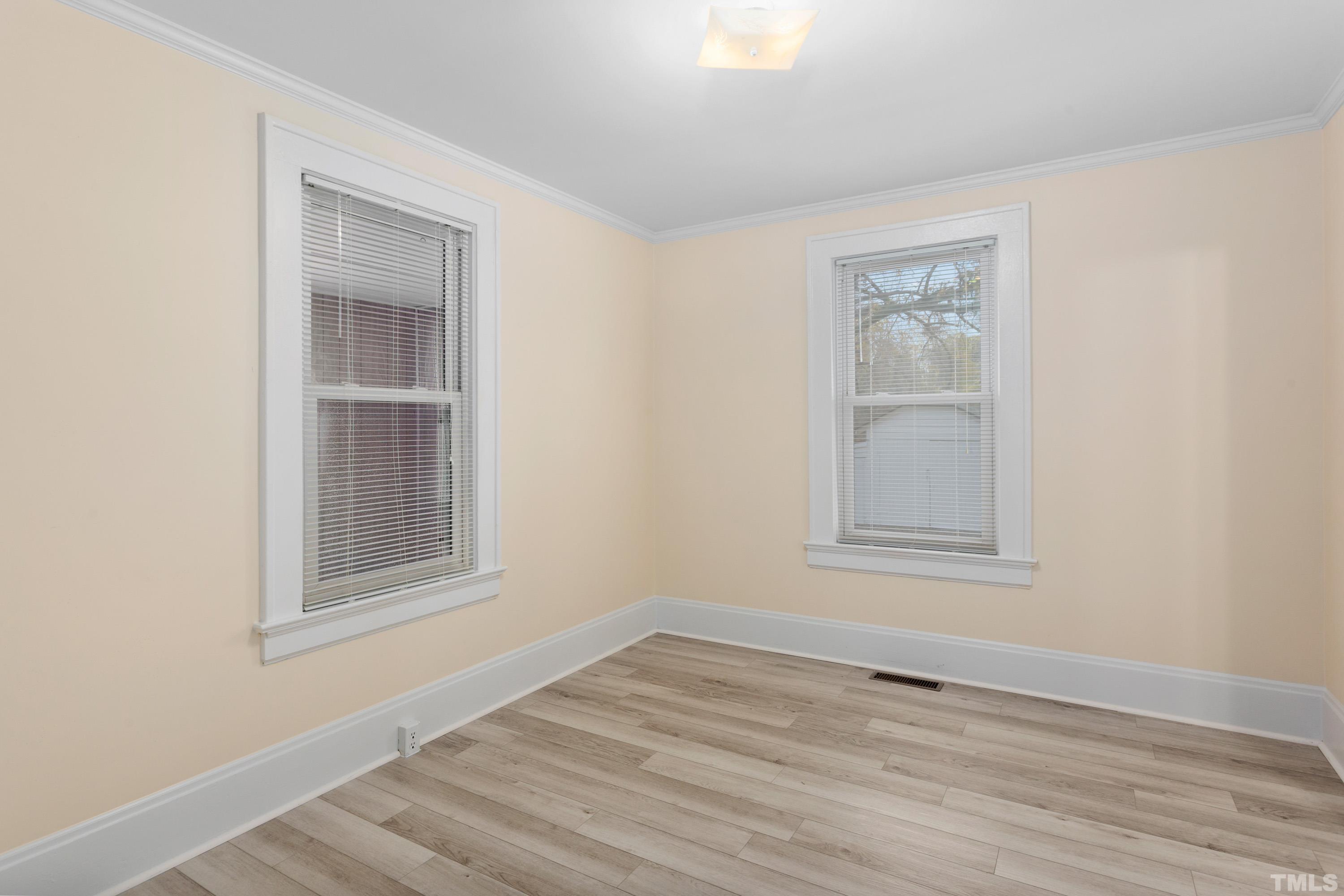111 Turner Street Raleigh, NC 27607 - Photo 19 of 26 a view of an empty room with wooden floor and a window