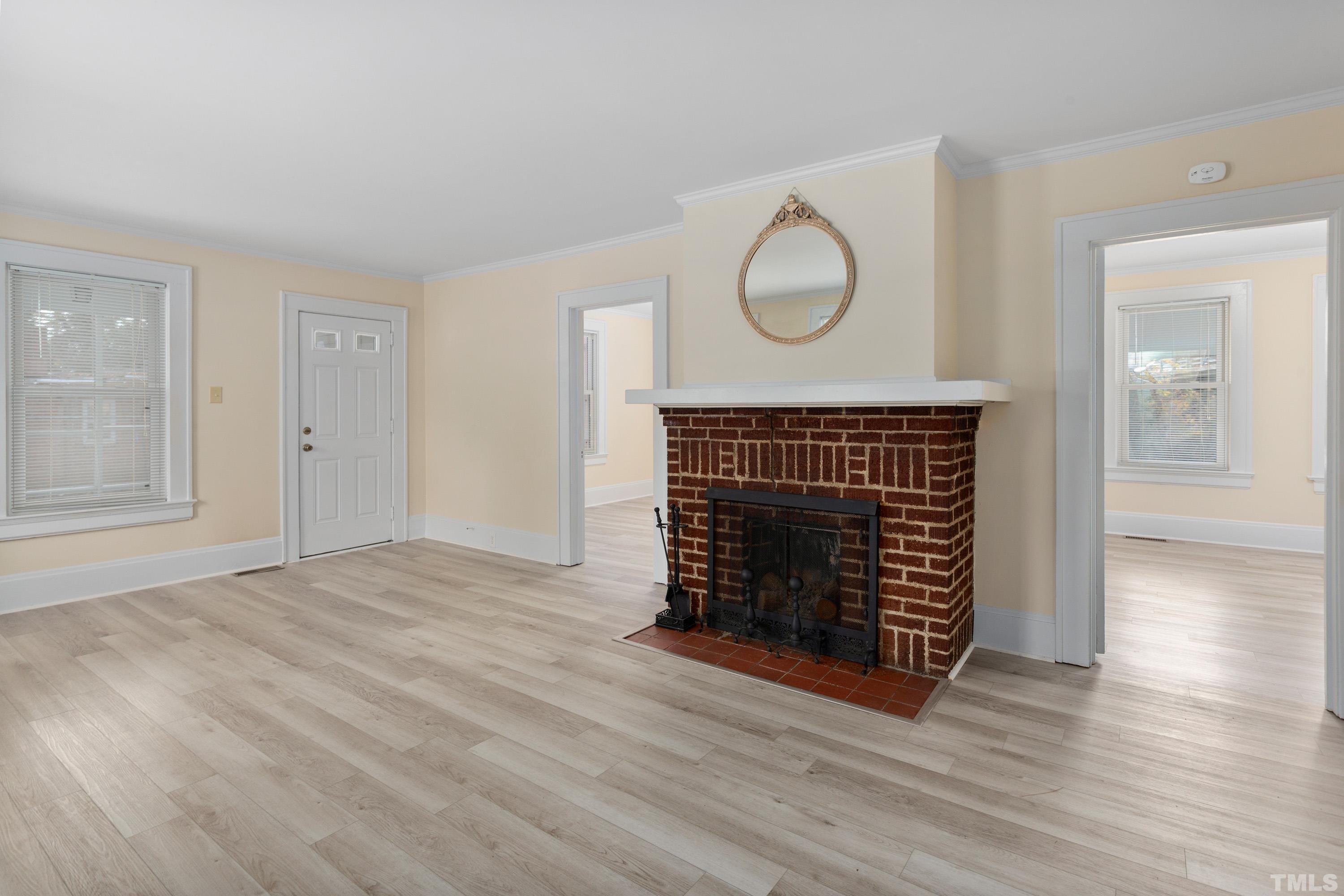 111 Turner Street Raleigh, NC 27607 - Photo 5 of 26 an empty room with wooden floor fireplace and window