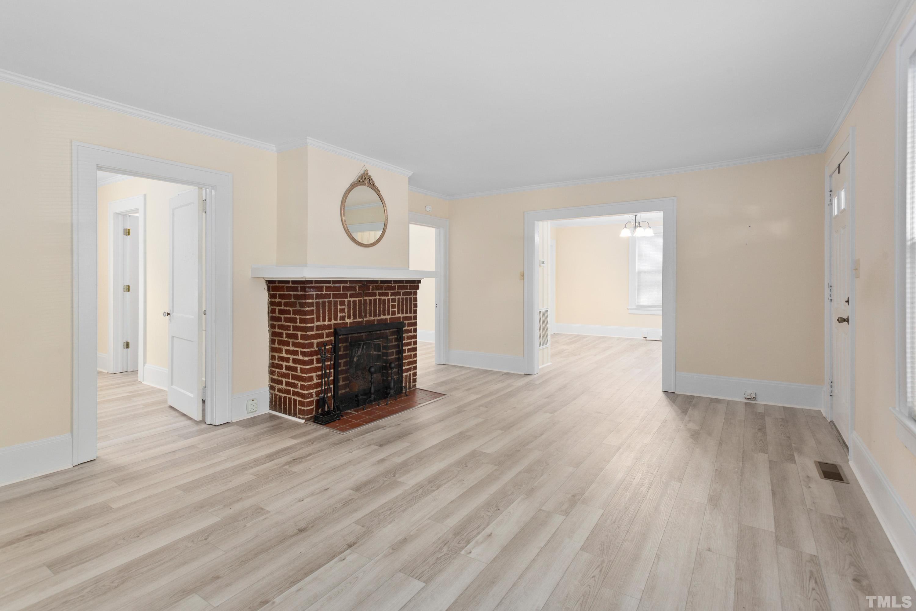 111 Turner Street Raleigh, NC 27607 - Photo 6 of 26 a view of empty room with wooden floor and fireplace