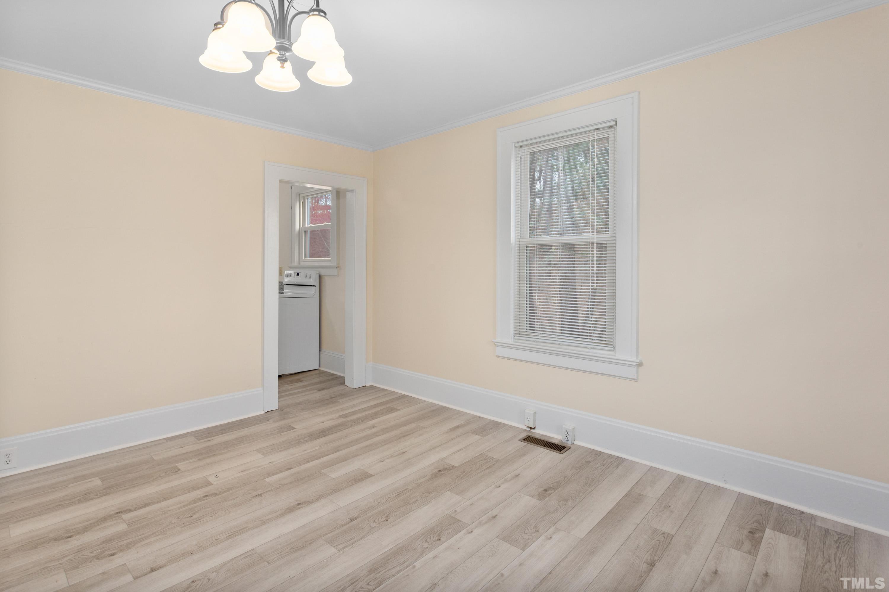 111 Turner Street Raleigh, NC 27607 - Photo 9 of 26 a view of an empty room with wooden floor and a window