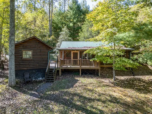a view of backyard of house with wooden fence and trees