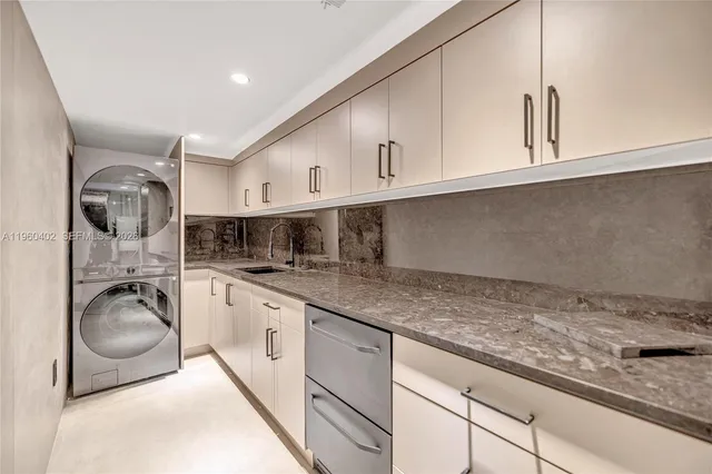 a large white kitchen with granite countertop a large window