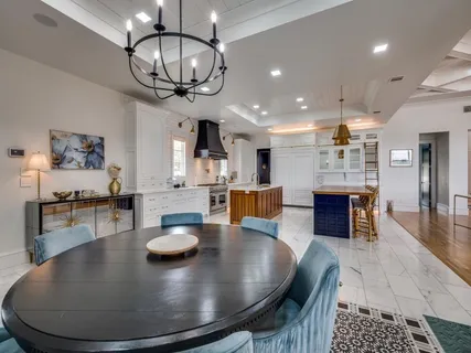 a living room with dining table a wooden floor and kitchen view