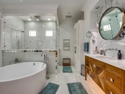 a spacious bathroom with a tub sink and mirror