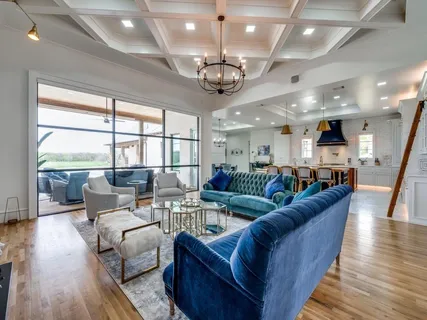 a living room with furniture a chandelier and a large window