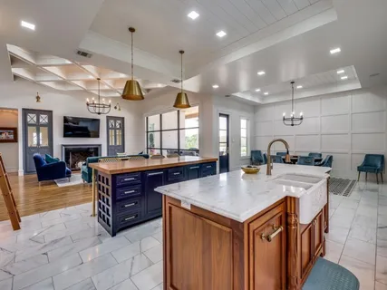 a kitchen with stainless steel appliances granite countertop a sink a oven and a wooden cabinets