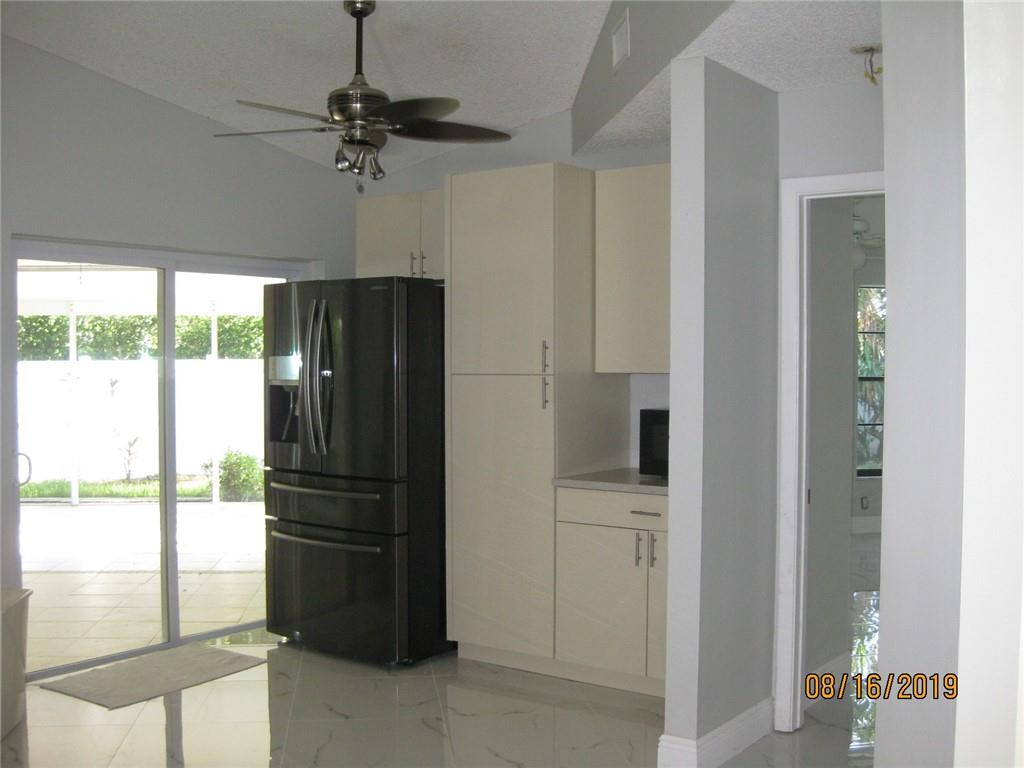 9629 Trivolo Place Boca Raton, FL 33434 - Photo 3 of 7 a kitchen with a refrigerator and a window