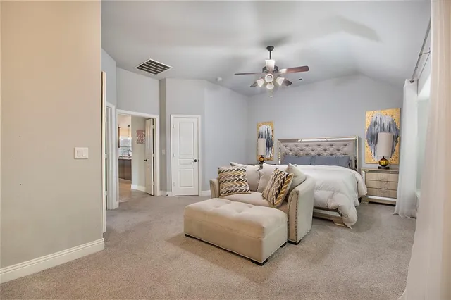 a bedroom with a bed ceiling fan and a rug