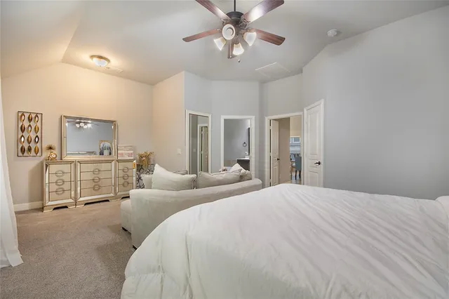a spacious bedroom with a bed and ceiling fan