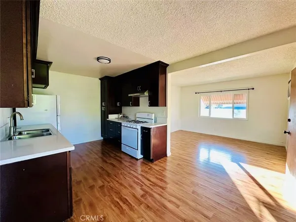 a large kitchen with kitchen island stainless steel appliances a sink counter space and wooden floor