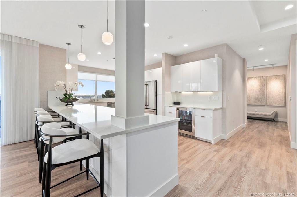 41 Southwest Seminole Street, Unit 206 Stuart, FL 34994 - Photo 29 of 79 a kitchen with kitchen island a wooden floor and chairs