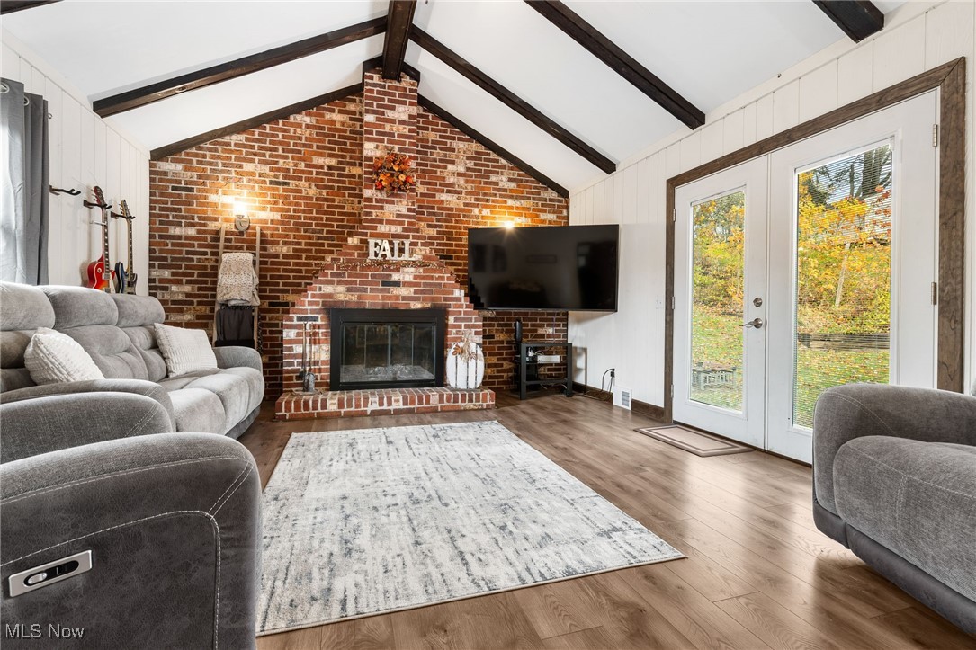 4727 15th Street Northwest Canton, OH 44708 - Photo 17 of 37 Living room with brick wall, wood finished floors, a brick fireplace, french doors, and wooden walls