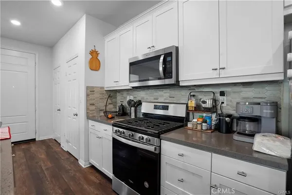 a kitchen with stainless steel appliances granite countertop a stove a sink and a microwave