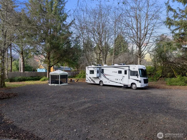 a view of a house with a yard and large trees