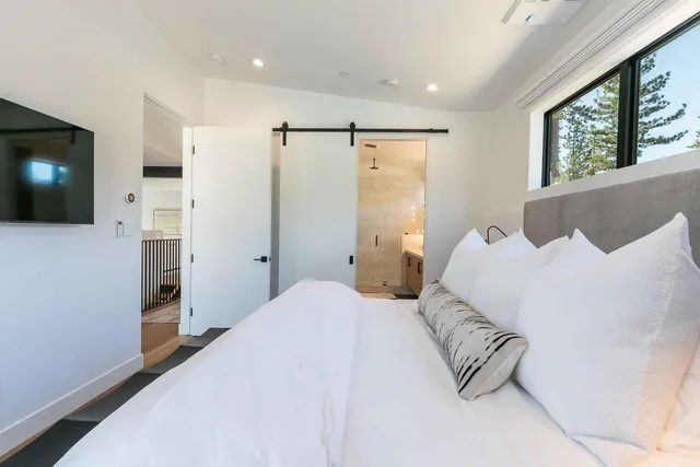 a bedroom with a large bed and a flat screen tv