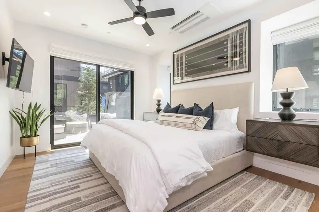 a spacious bedroom with a large bed and a chandelier