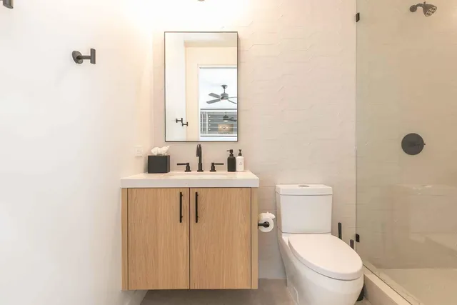 a bathroom with a sink a toilet and a mirror