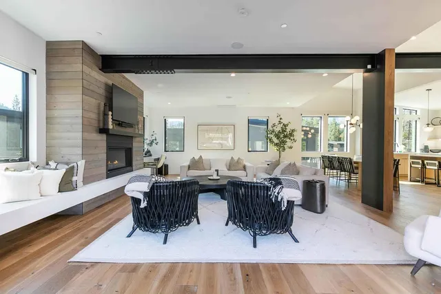 a living room with furniture a large window and wooden floor