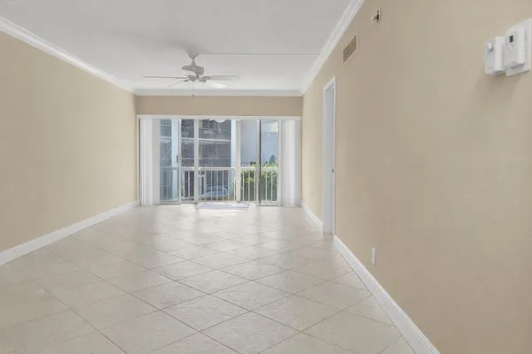 a living room with furniture a flat screen tv and a floor to ceiling window