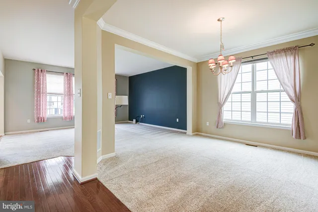 an empty room with chandelier and windows