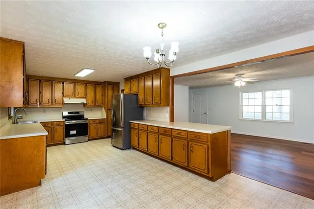 a large kitchen with stainless steel appliances granite countertop a sink counter space and wooden floor