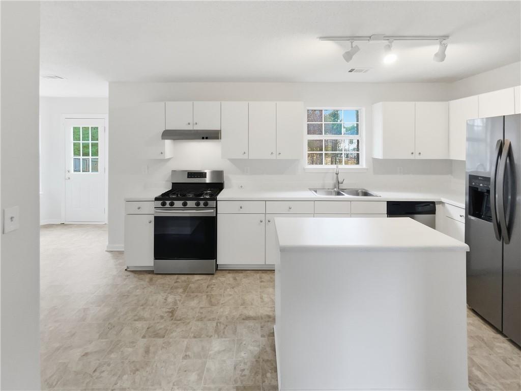 836 Tara Bend Hampton, GA 30228 - Photo 8 of 25 a kitchen with a sink a stove a refrigerator and white cabinets