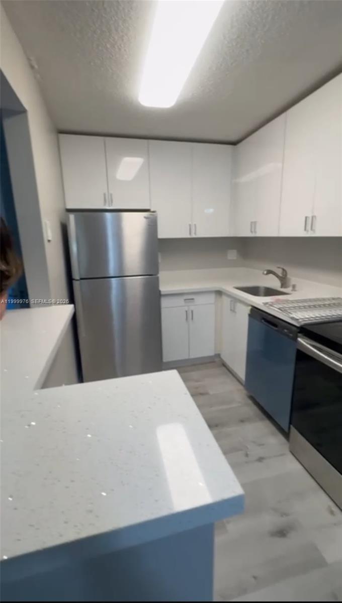 a kitchen with a sink dishwasher and a refrigerator