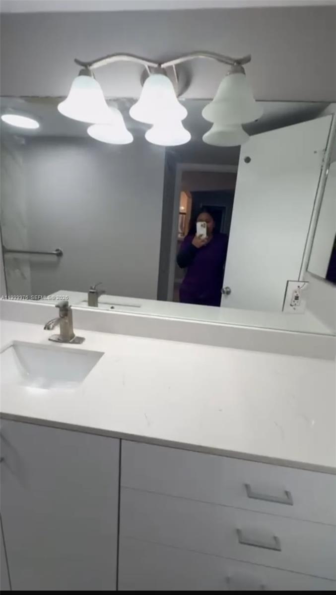 7100 Northwest 179th Street, Unit 102 Hialeah, FL 33015 - Photo 5 of 7 a bathroom with a sink and a mirror