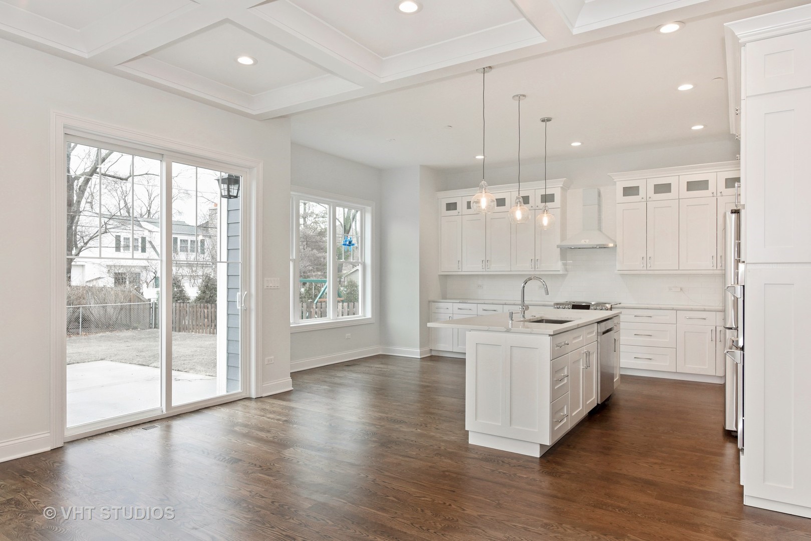 2424 Illinois Road Northbrook, IL 60062 - Photo 4 of 14 a large white kitchen with granite countertop a stove top oven a chimney wooden floor and cabinets