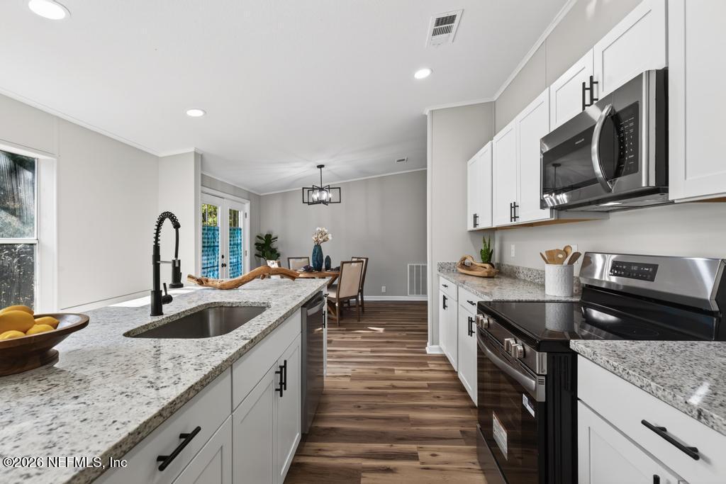 216 Yucca Street Middleburg, FL 32068 - Photo 17 of 60 a kitchen with stainless steel appliances granite countertop a sink stove and microwave