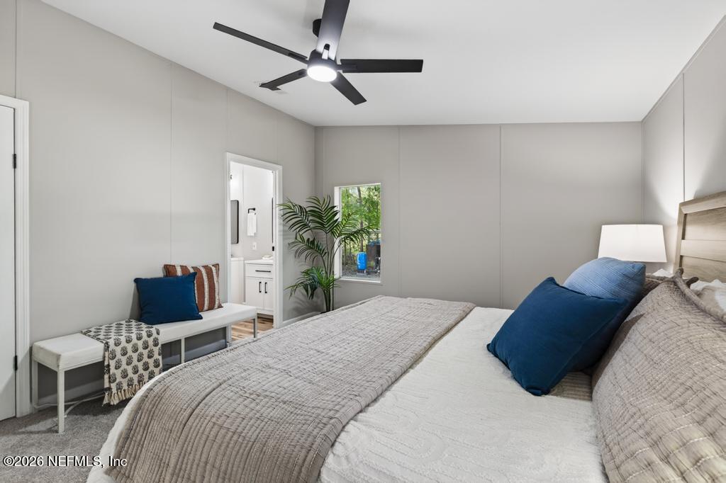 216 Yucca Street Middleburg, FL 32068 - Photo 30 of 60 a bedroom with a bed lamp and a potted plant