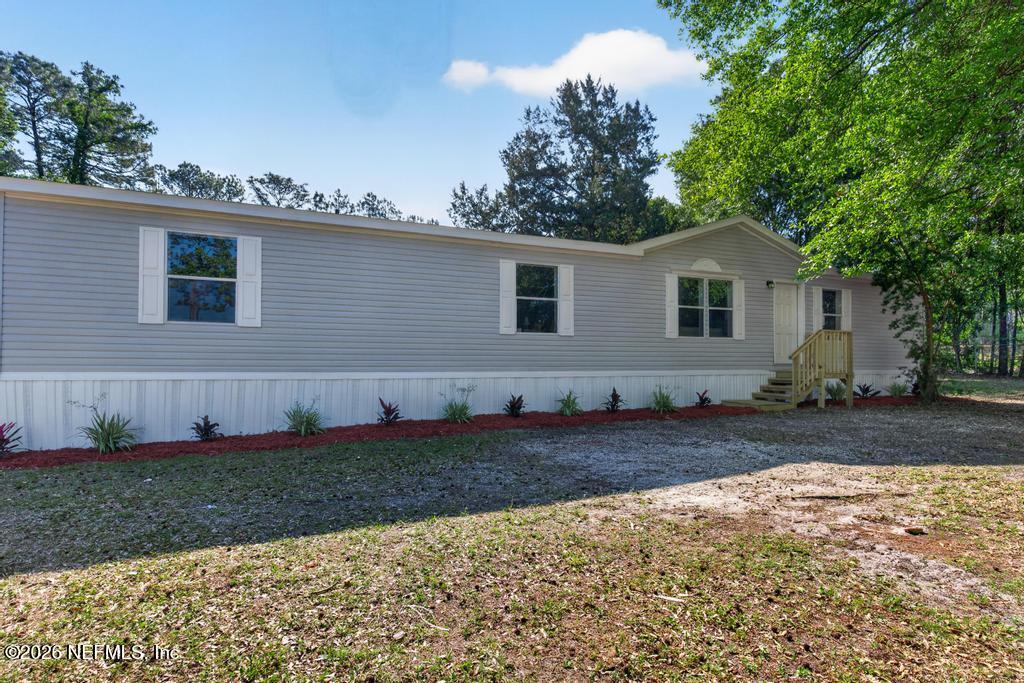 216 Yucca Street Middleburg, FL 32068 - Photo 4 of 60 a view of a yard in front of a house with large trees