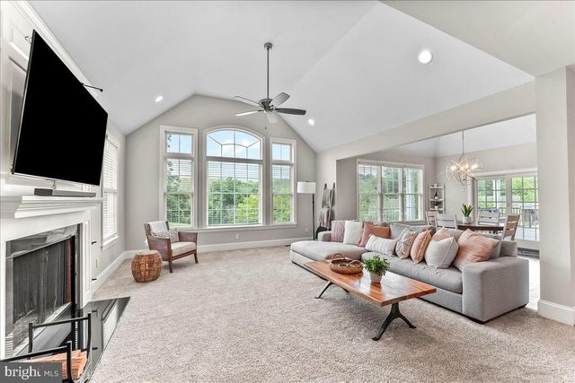 a living room with furniture a flat screen tv and a large window