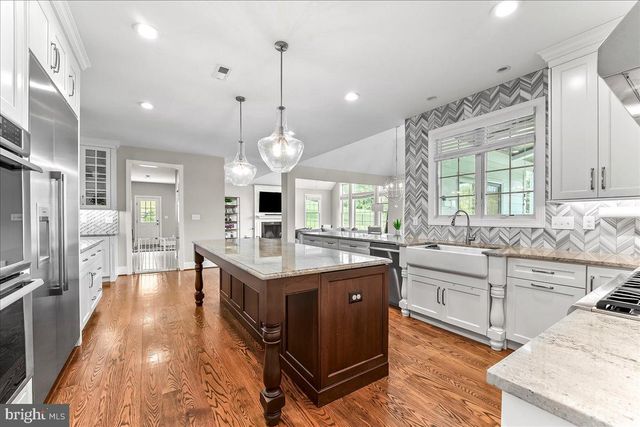 a dining room with wooden floor a chandelier a wooden table and chairs
