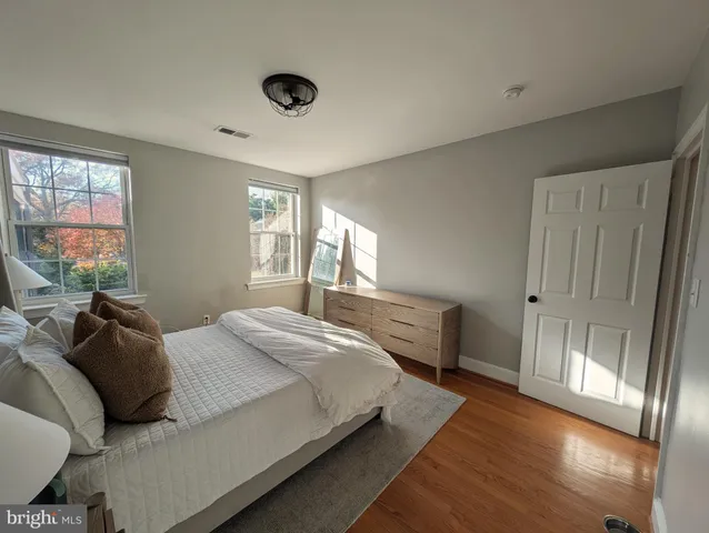 a bedroom with a balcony a bed and a large window