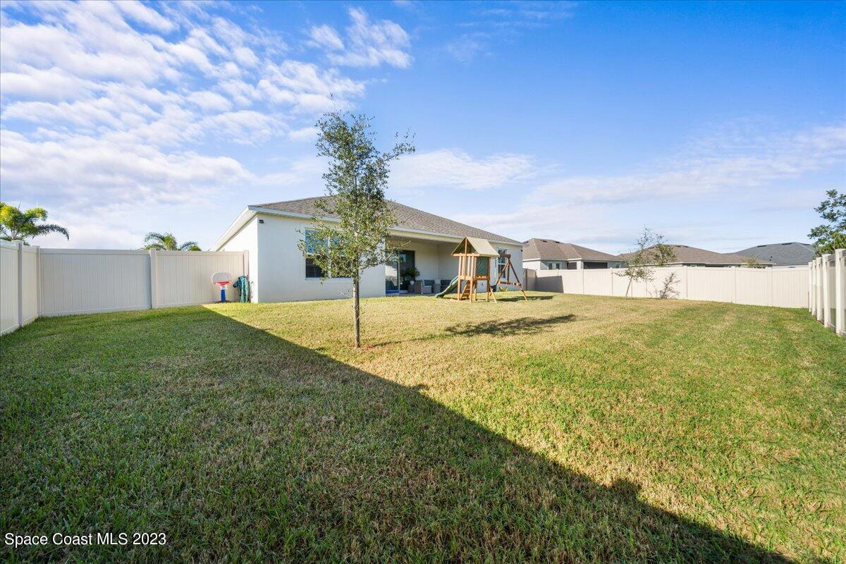 1582 Killian Drive Palm Bay, FL 32905 - Photo 30 of 37 a house with green field in front of it