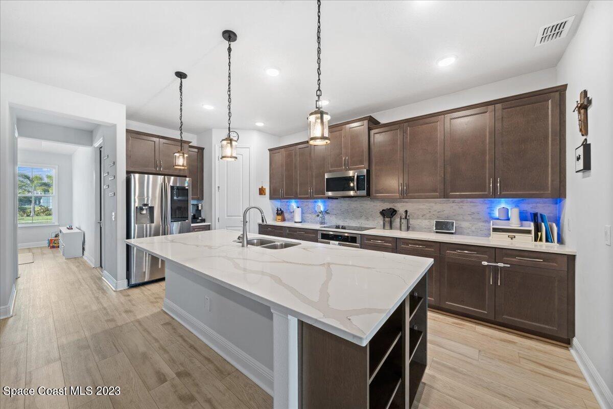 1582 Killian Drive Palm Bay, FL 32905 - Photo 4 of 37 a kitchen with kitchen island a sink appliances and cabinets