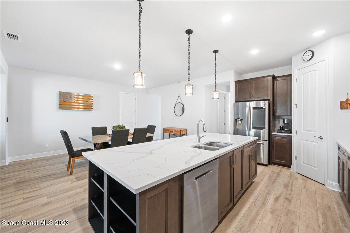 1582 Killian Drive Palm Bay, FL 32905 - Photo 5 of 37 a kitchen that has a kitchen island a stove a table and chairs
