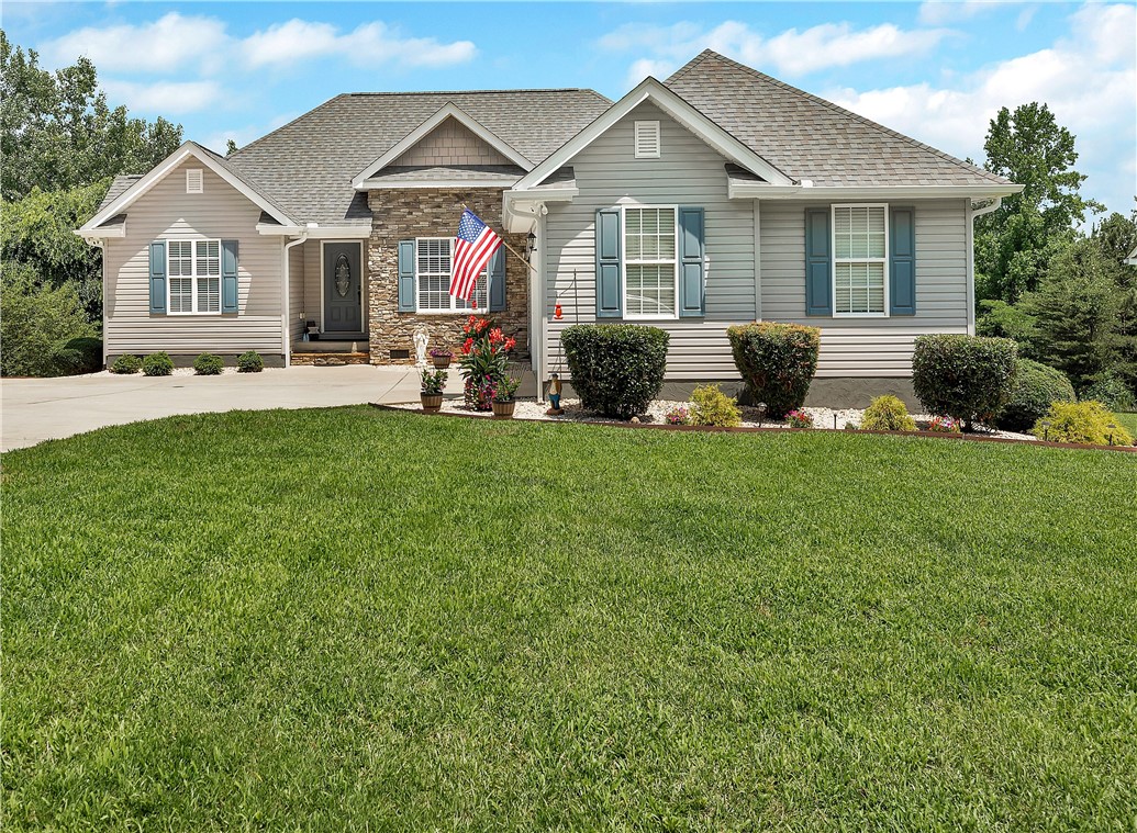 131 Morgan Road West Union, SC 29696 - Photo 1 of 39 A welcoming facade with a stone accent entry and classic blue shutters, complemented by a neatly kept lawn.