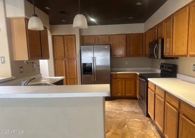 a kitchen with stainless steel appliances granite countertop a sink a stove and a refrigerator