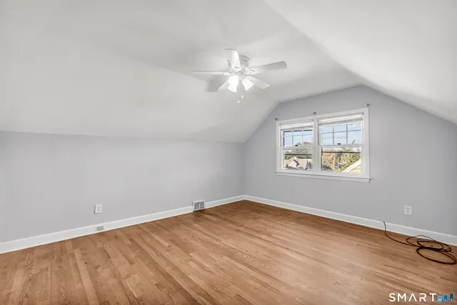 an empty room with a window and ceiling fan