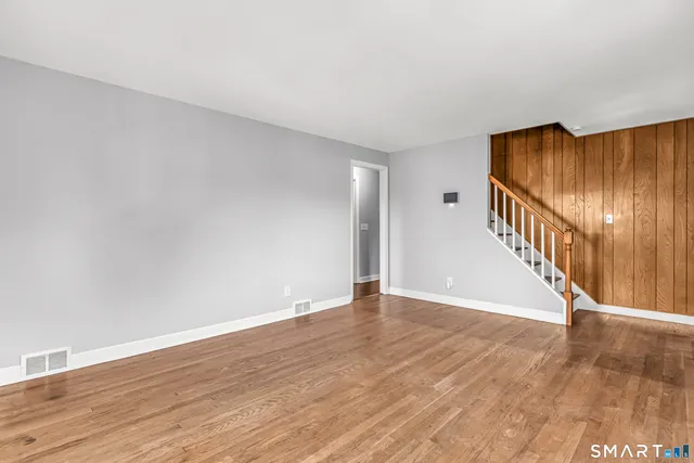 a view of an empty room with wooden floor