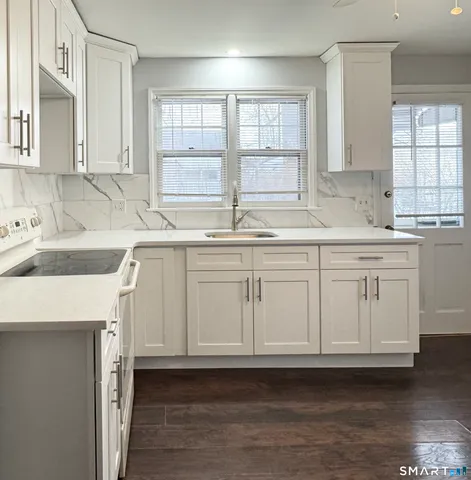 a kitchen with white cabinets and sink